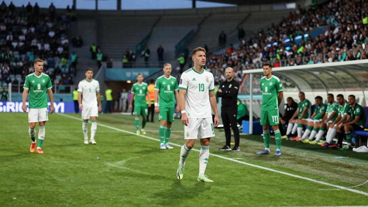 Trener pored klupe, igrači u zeleno-bijelom